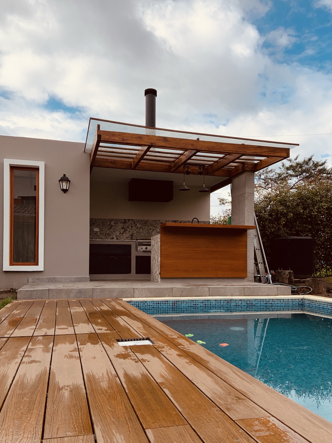 Residencia construida en Cumbayá: readecuación exterior con deck de madera, piscina y cocina exterior cubierta